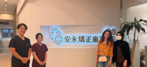 Dental clinic staff and visitors standing by sign