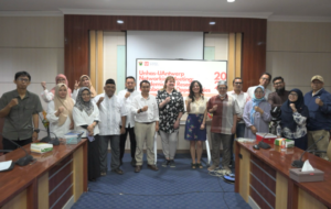 Group posing in conference room with raised fists