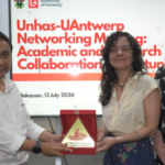 Three people holding award plaque at networking event