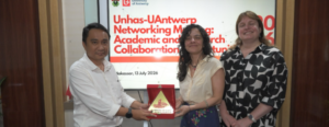 Three people holding award plaque at networking event