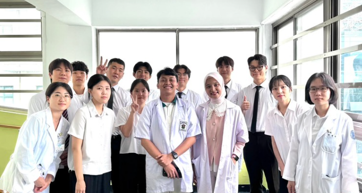 Group of students in lab coats indoors