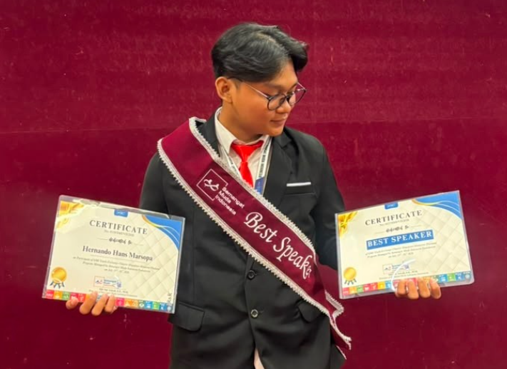 Young award winner holding two certificates and sash