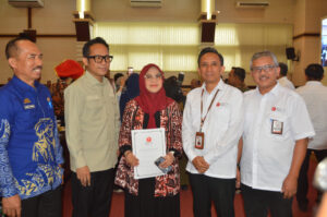 Pejabat berfoto bersama memegang dokumen BRIN
