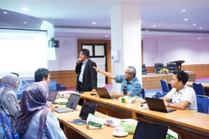 Peserta berdiskusi dalam rapat dengan laptop di ruang konferensi