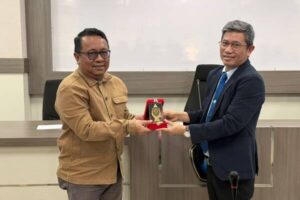 Dua pria bertukar plakat penghargaan resmi