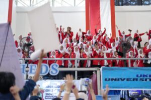 Mahasiswi berseragam merah bersorak di tribun