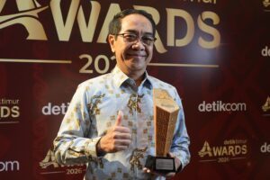 Pria memegang piala di acara penghargaan