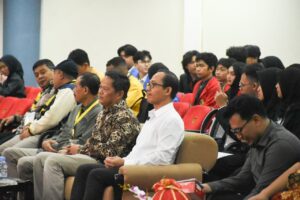Peserta menghadiri acara di auditorium dengan kursi merah