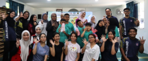 Smiling group poses together indoors with raised hands