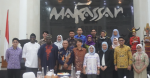 Diverse group poses beneath Mahassar sign