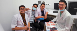 Four smiling medical professionals in white coats at a clinic