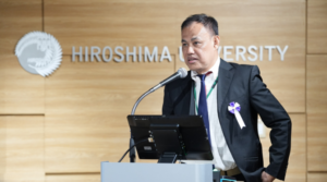 Man speaking at Hiroshima University podium