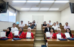 Students holding certificates with faculty in a classroom