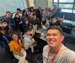 Smiling coworkers pose for a group office selfie