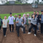 Group posing in a cultivated hillside field