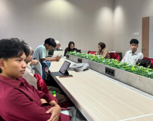 Students seated around a conference table with laptops
