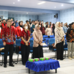 Audience standing in auditorium during formal event