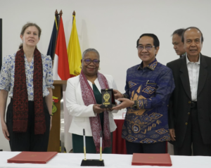 Officials exchange commemorative plaque during formal signing ceremony