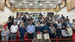 Large diverse group posing in a lecture hall