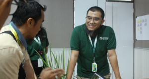 Colleagues discussing work around a table in an office