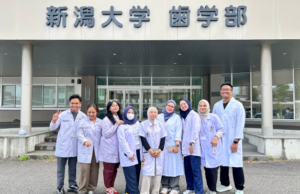 Dental students in lab coats outside Niigata University