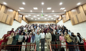 Large group posing in a modern lecture hall