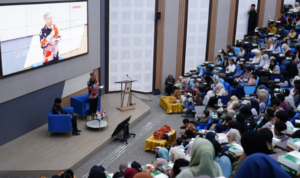 Speaker addresses audience in a crowded lecture hall