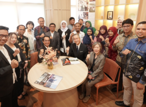 Diverse group poses around table with raised fists