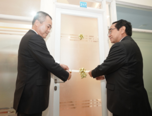 Two men in suits open office door 217