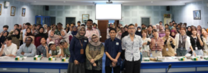 Large group posing in a classroom or lecture hall