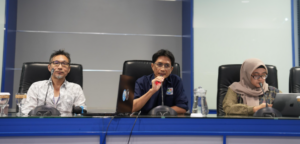 Three officials seated at a conference table