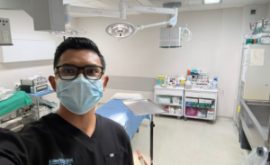 Masked healthcare worker takes selfie in operating room