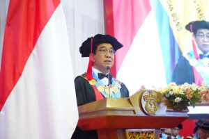 Rektor berpidato di podium saat wisuda kampus