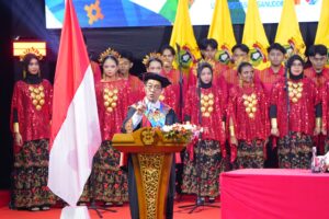 Pejabat berpidato di panggung bersama penari tradisional