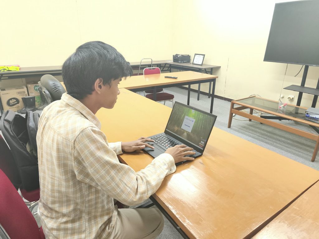 Man using laptop at conference room table