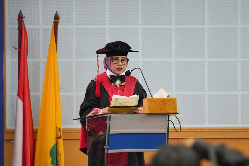 Pria berjubah akademik berpidato di podium