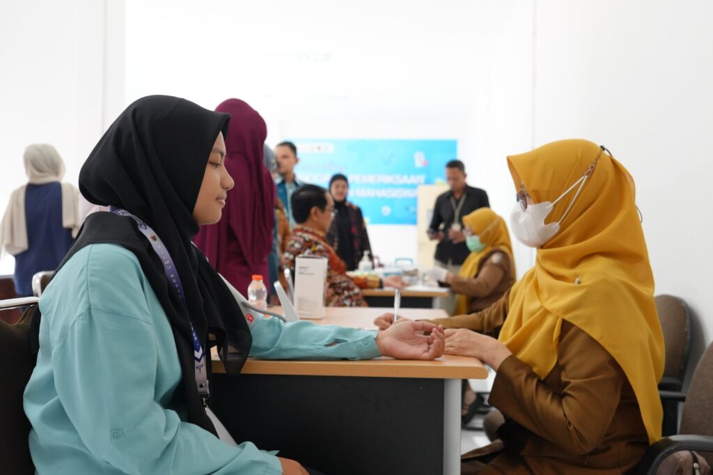 Petugas memeriksa kesehatan perempuan di acara layanan publik