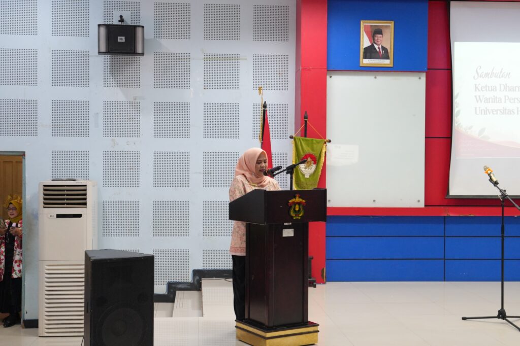 Perempuan berhijab menyampaikan sambutan di podium acara