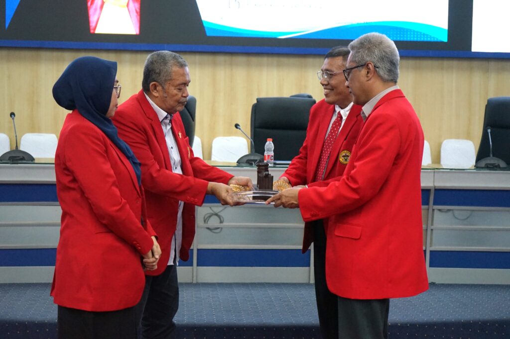 Penyerahan plakat oleh pejabat berblazer merah