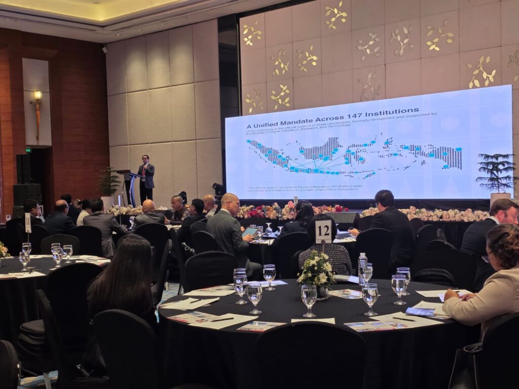 Pembicara mempresentasikan peta jaringan universitas di forum konferensi.