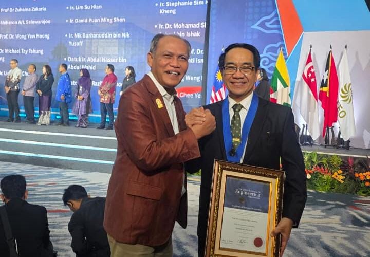 Dua pria berfoto dengan sertifikat penghargaan di panggung