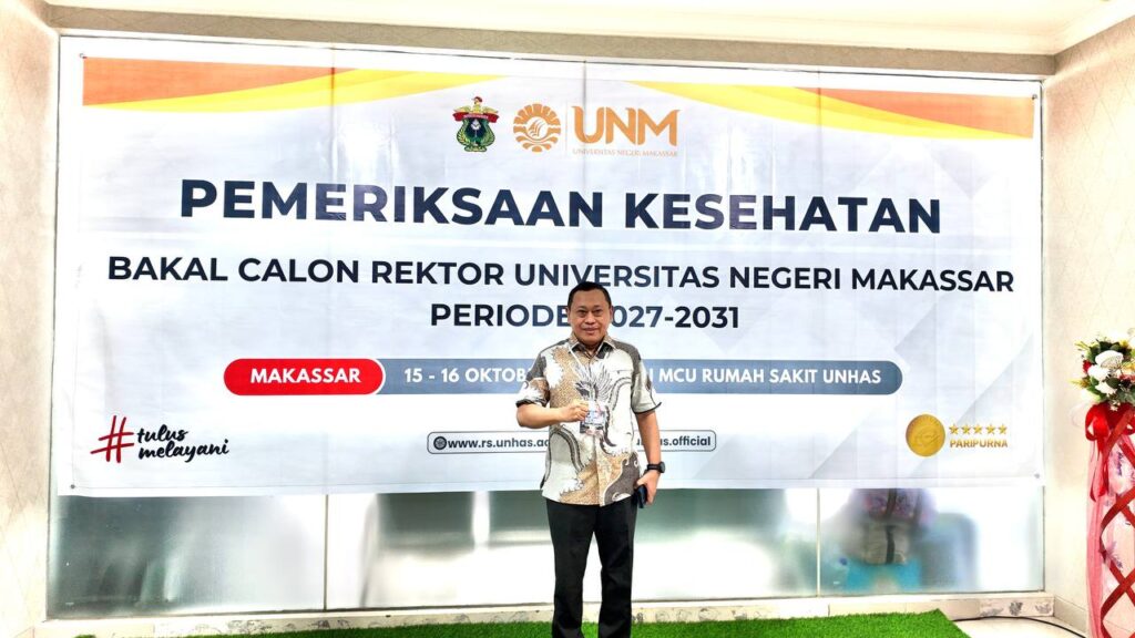 Pria berfoto di depan spanduk pemeriksaan kesehatan calon rektor UNM