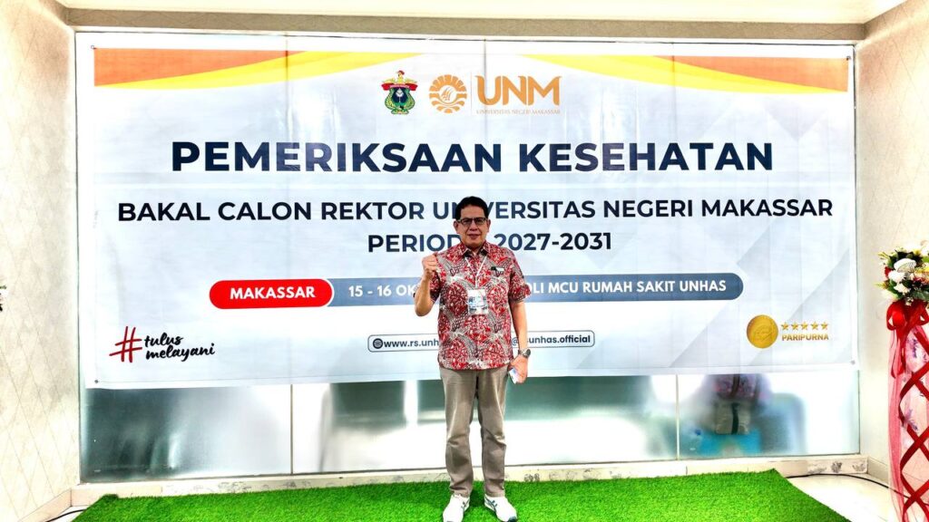 Pria berpose di depan spanduk pemeriksaan kesehatan UNM