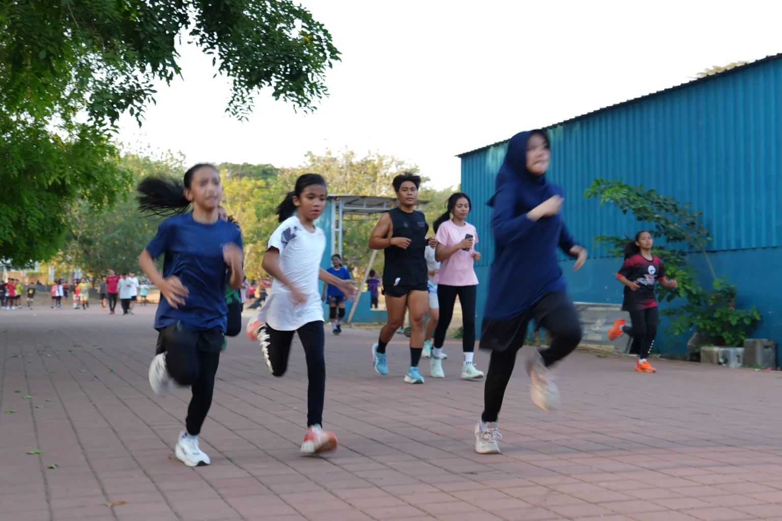 Sekelompok perempuan berlari di jalur luar ruangan