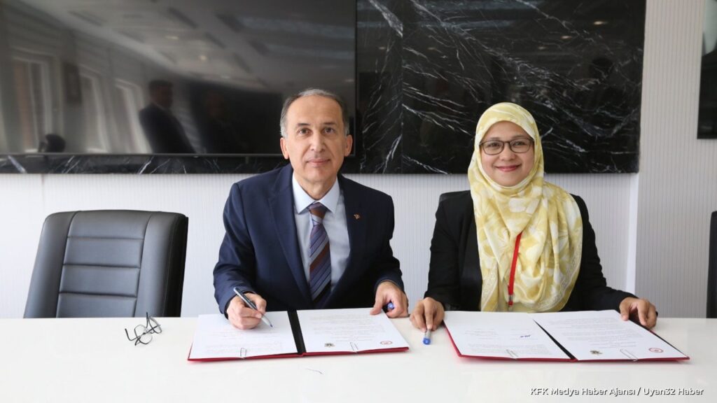 Two officials sign a cooperation document at a table