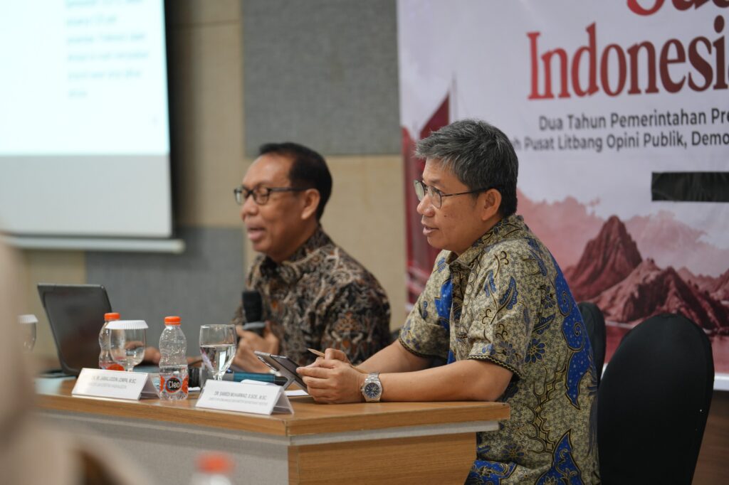 Dua pria berbaju batik dalam forum diskusi Indonesia