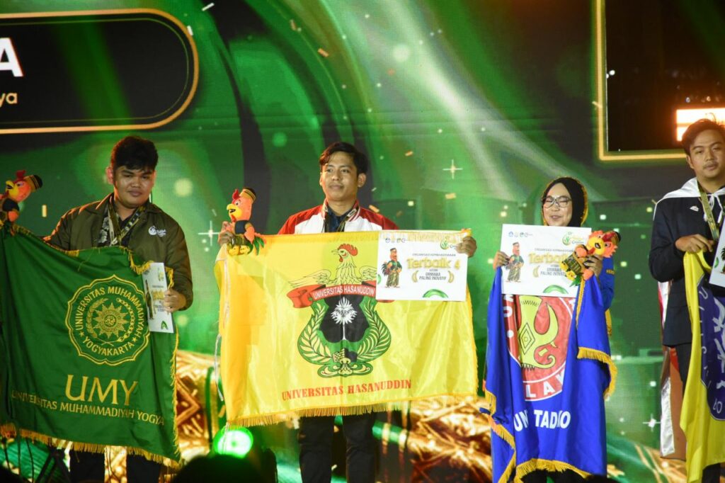 Mahasiswa membawa bendera universitas pada acara penghargaan